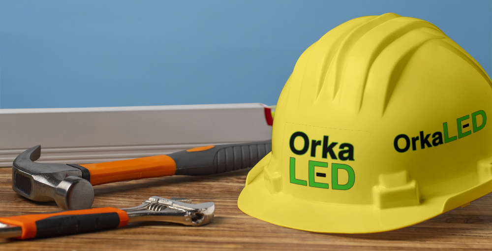 Reformas Orkaled Casco de obra con el logotipo de Orkaled junto a herramientas