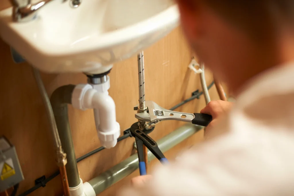 Fontanero reparando las tuberías de un lavabo