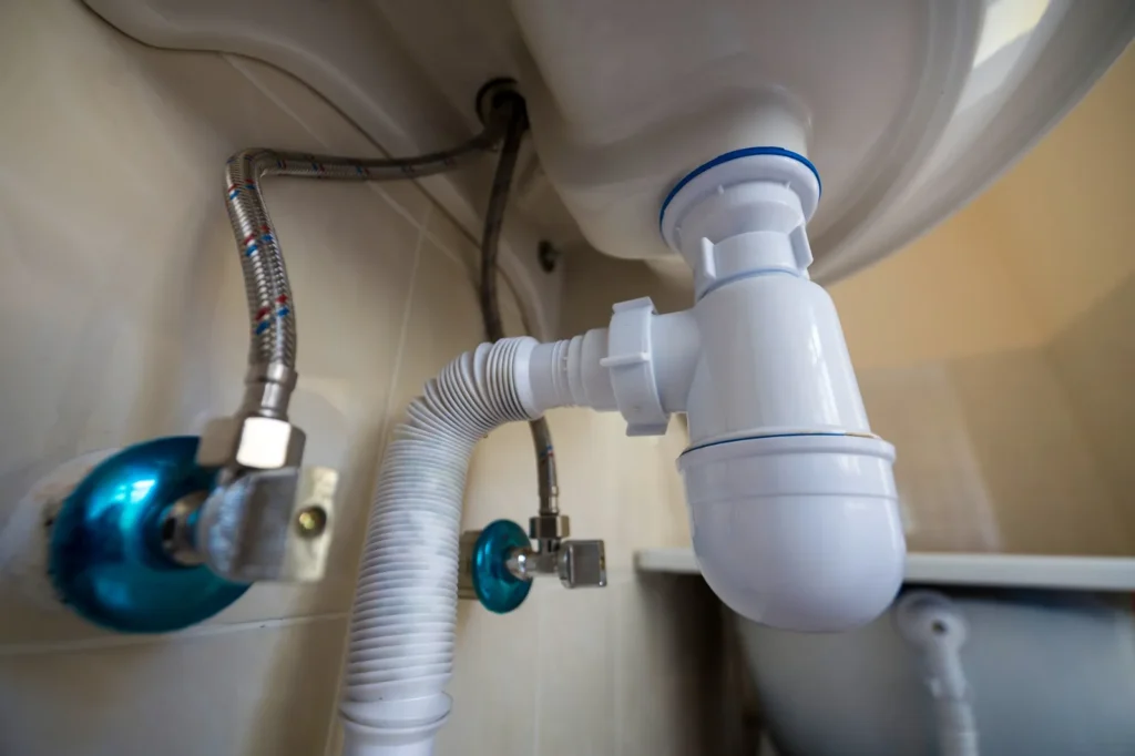 Sifón y tuberías de desagüe bajo un lavabo